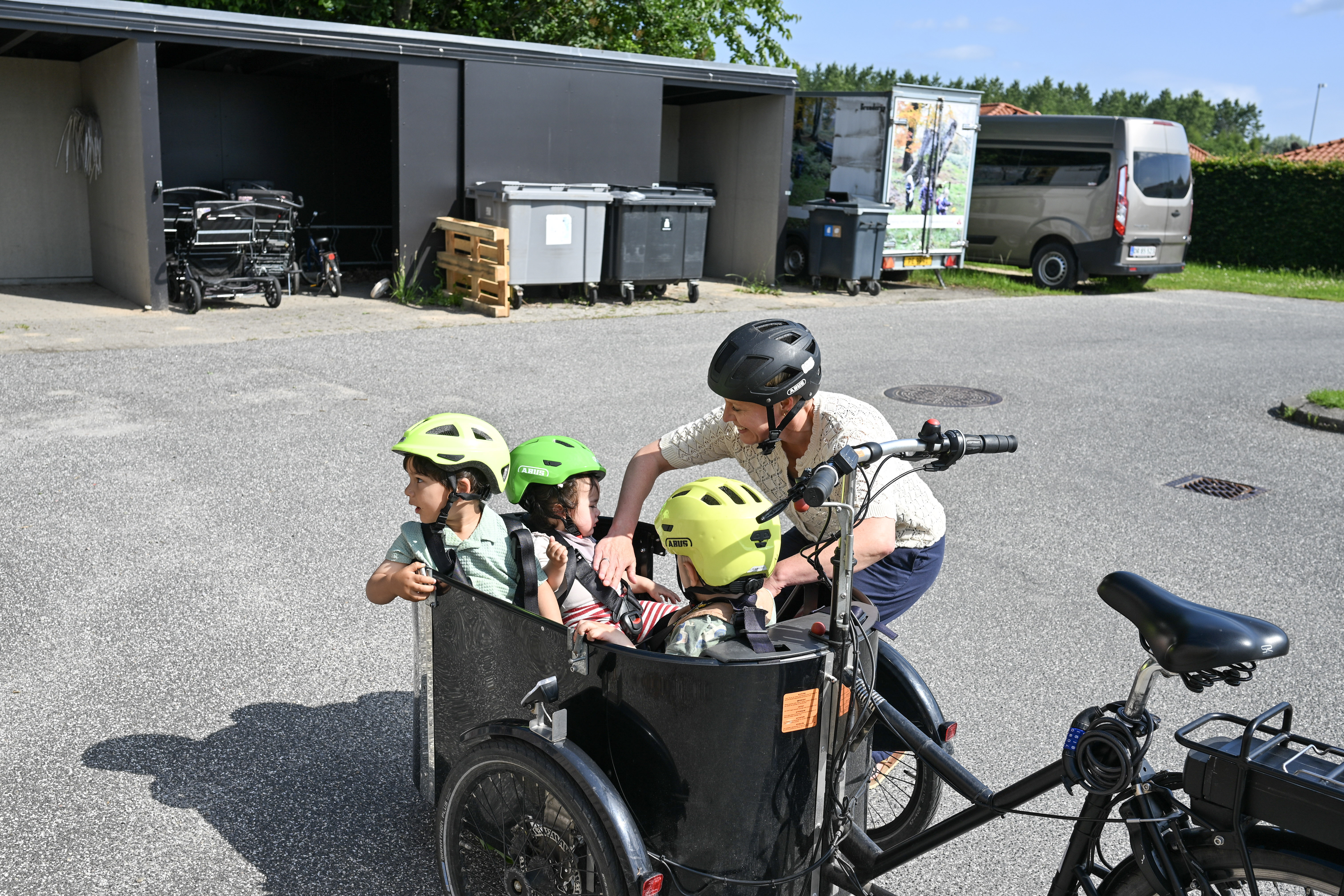 Voksen med børn på ladcykel