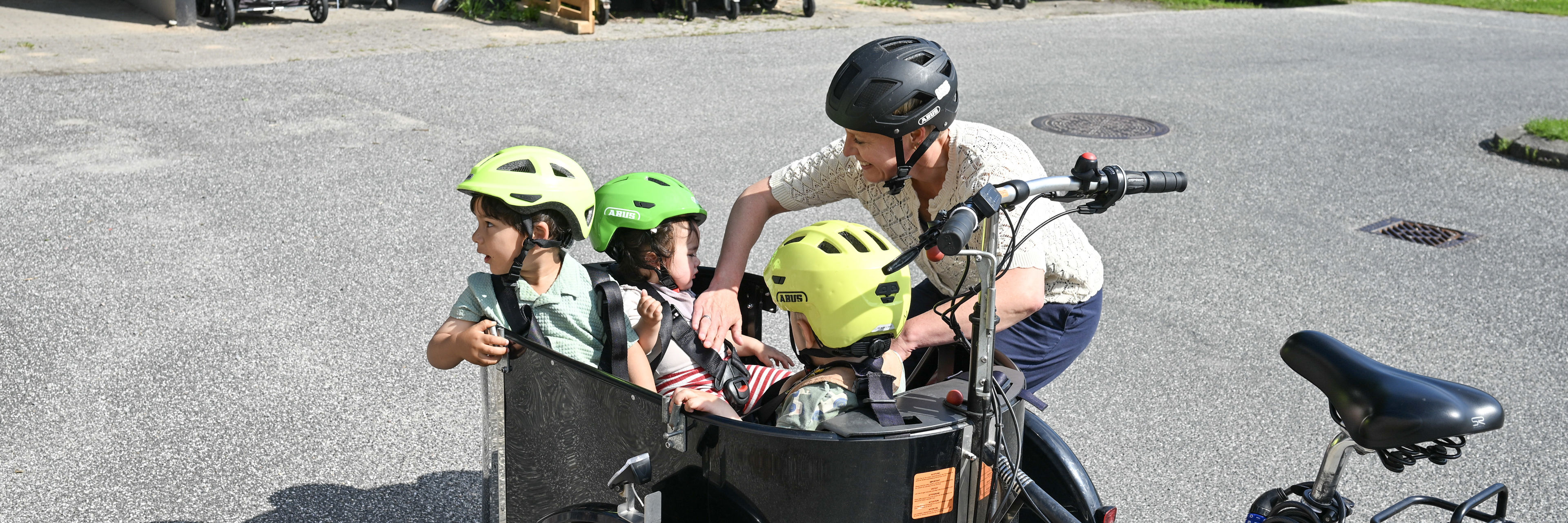 Voksen med børn på ladcykel