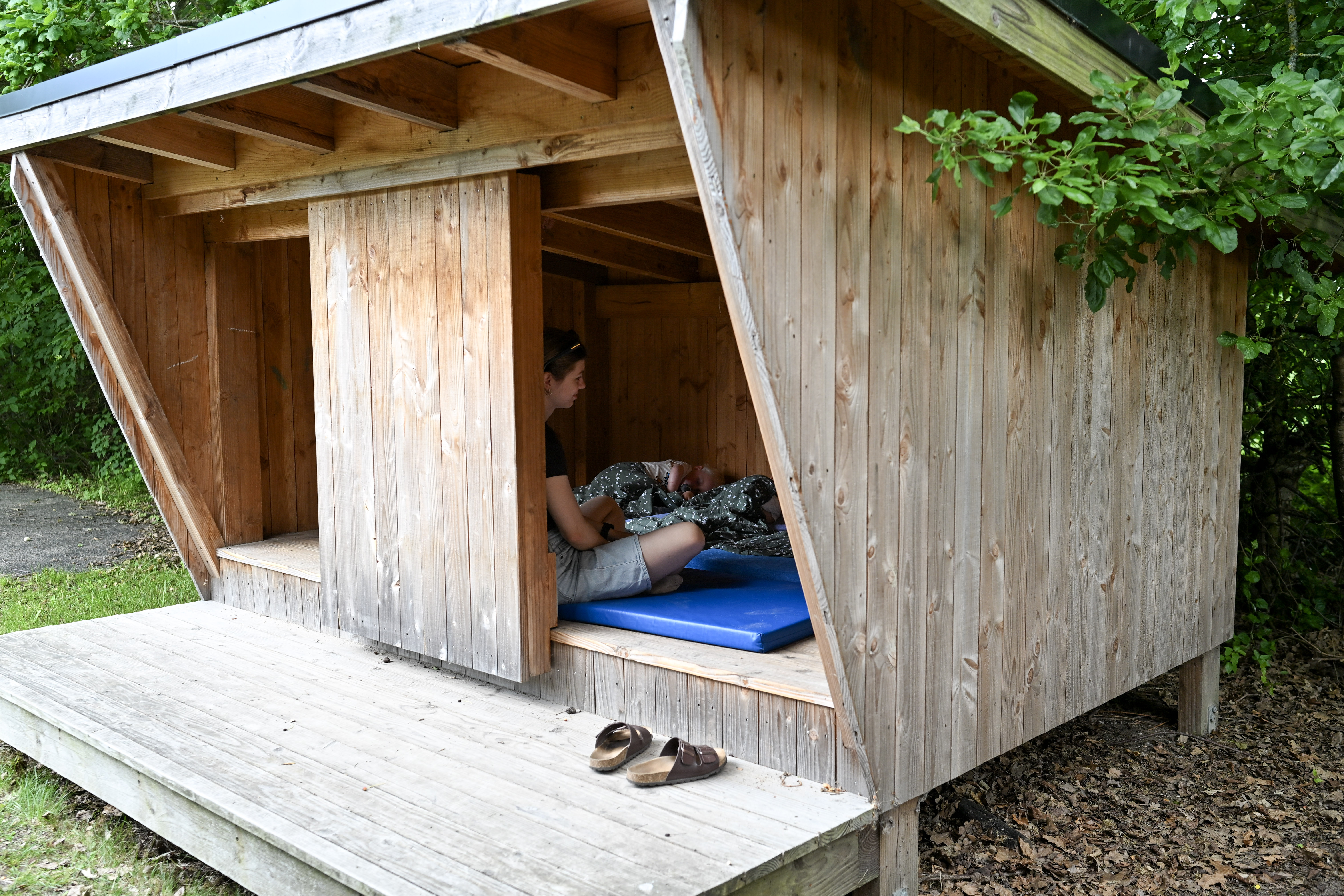 Voksen kigger på børn, der sover i shelter